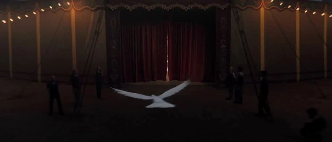 Video still from the Kling 4.0 circus one-take showing a white dove flying inside a dimly lit Victorian circus tent